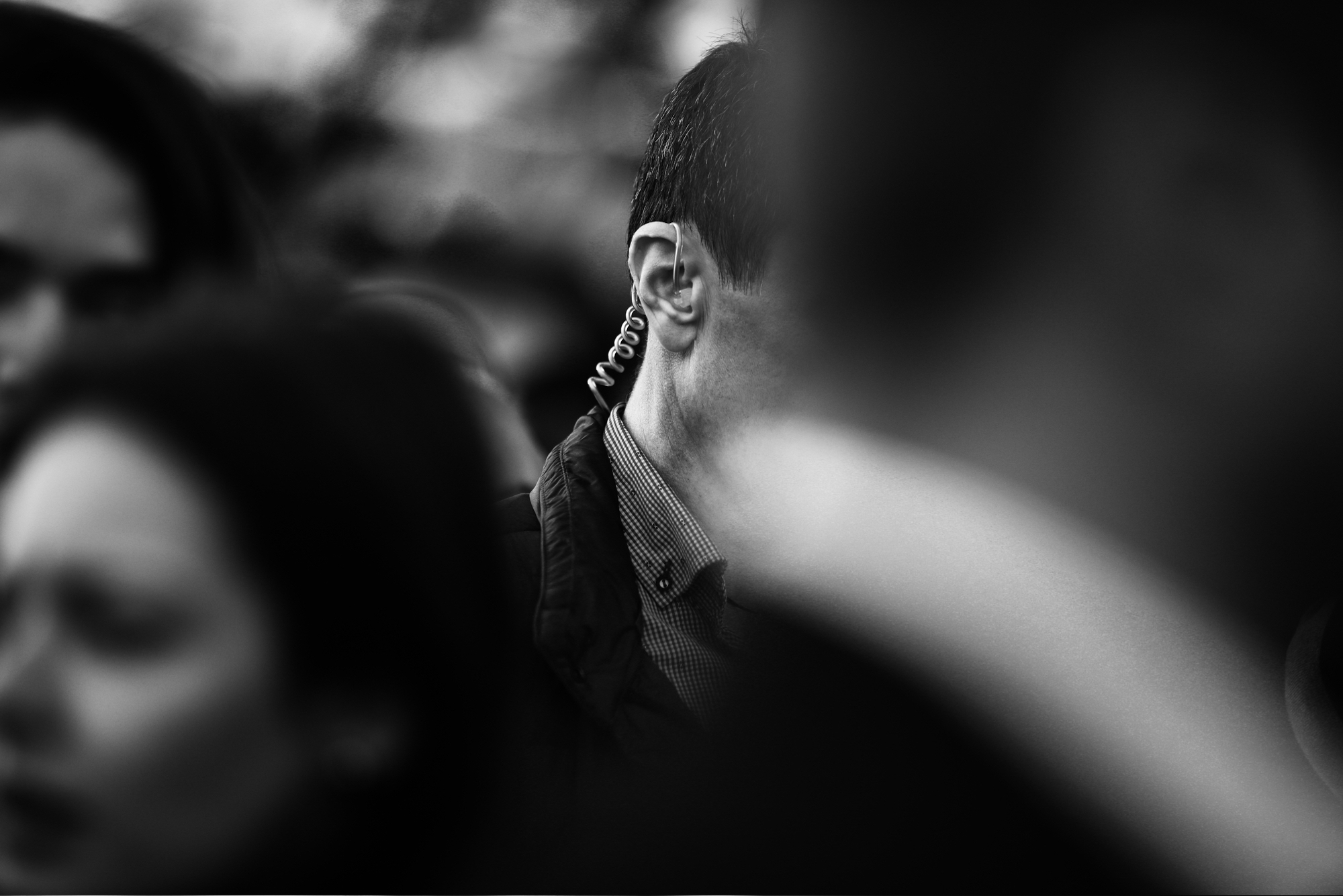 Shallow depth of field (selective focus) image with the coiled tube earpiece a Protection and Guard Service (SPP, Romanian version of the US Secret Service) officer is wearing during a public visit of a dignitary.